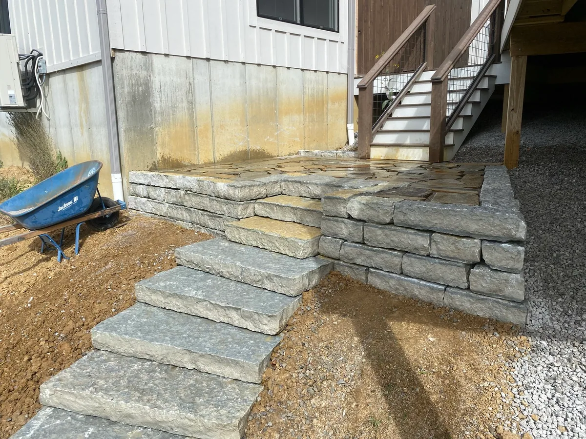 Stone steps and retaining wall completed by Queen City Hardscapes